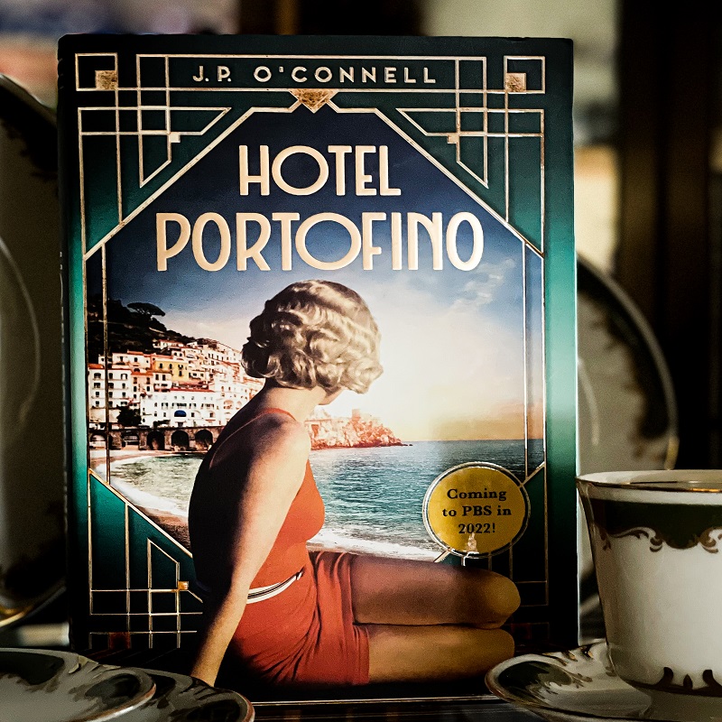 A picture of the Hotel Portofino surrounded by antique plates and saucers.