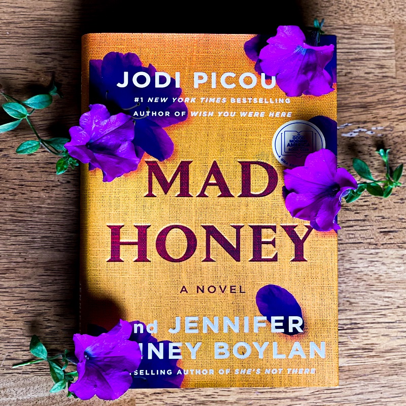 : A picture of Mad Honey surrounded by purple flowers.