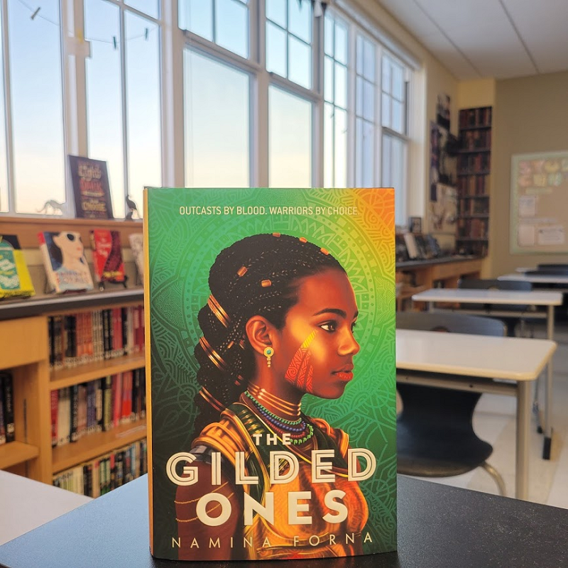 A copy of The Gilded Ones in a classroom